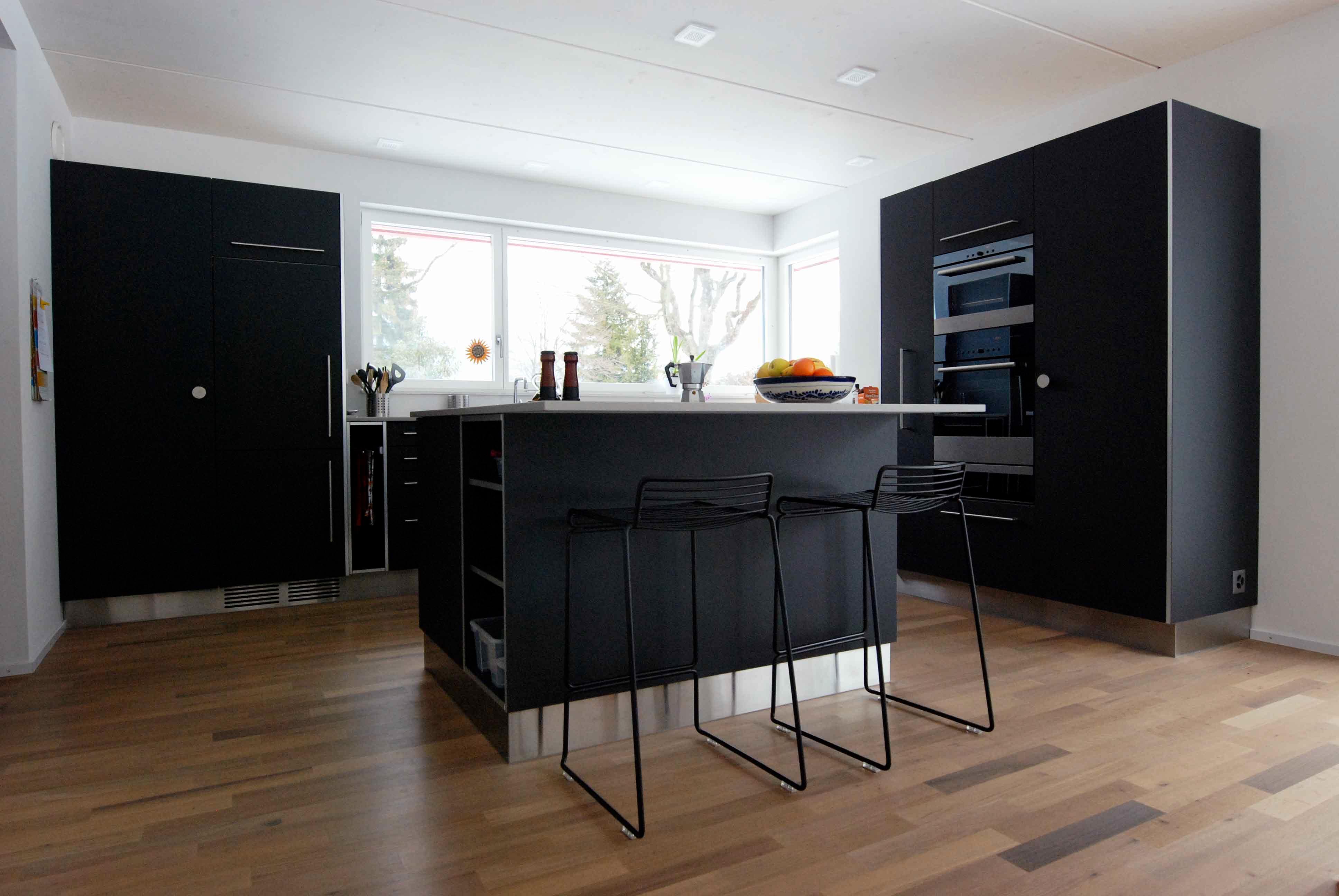  Architektur-Reportage Thun roter Kubus: moderne Küche in schwarz mit Fichtenholzboden 