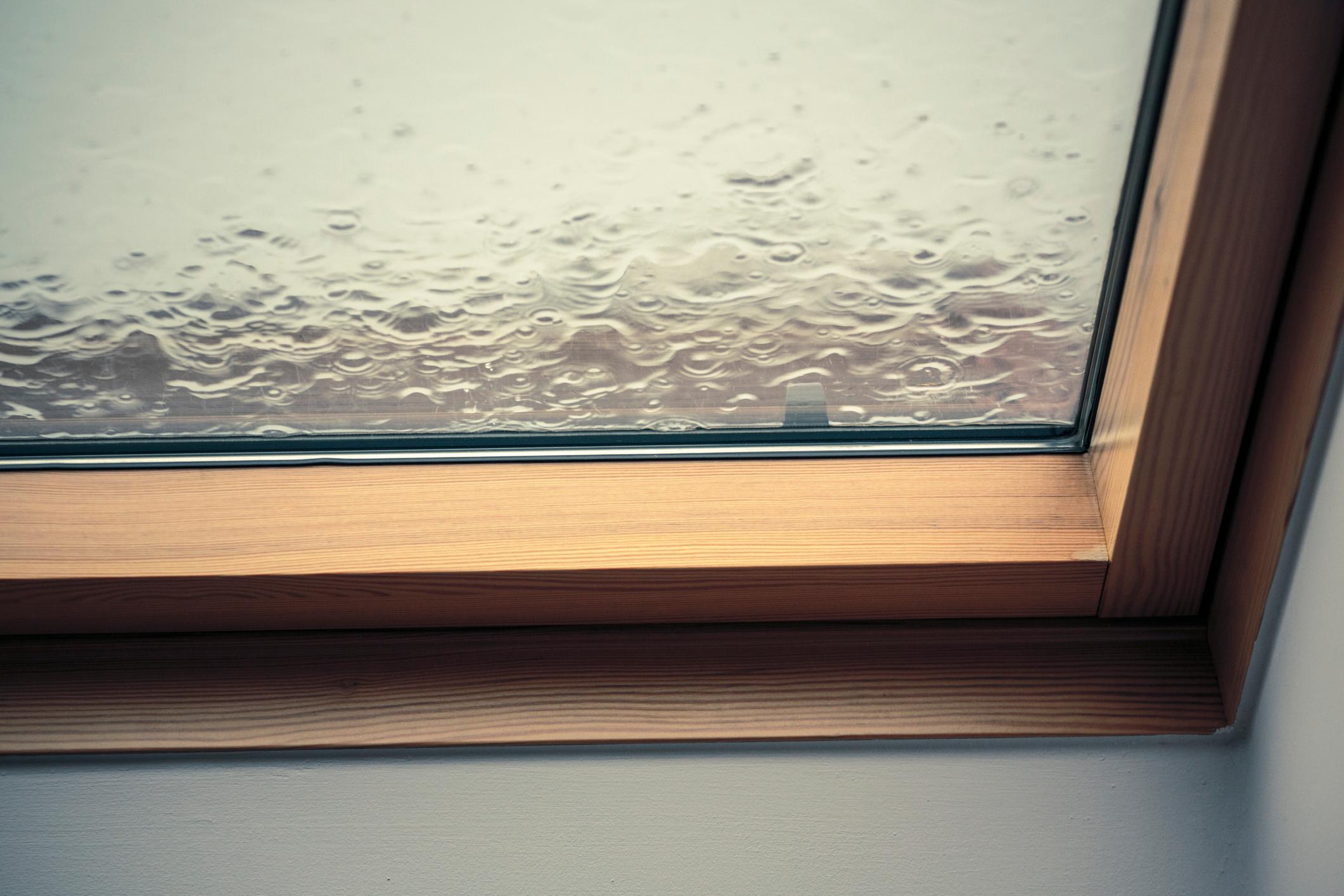Es regnet auf ein Dachfenster.