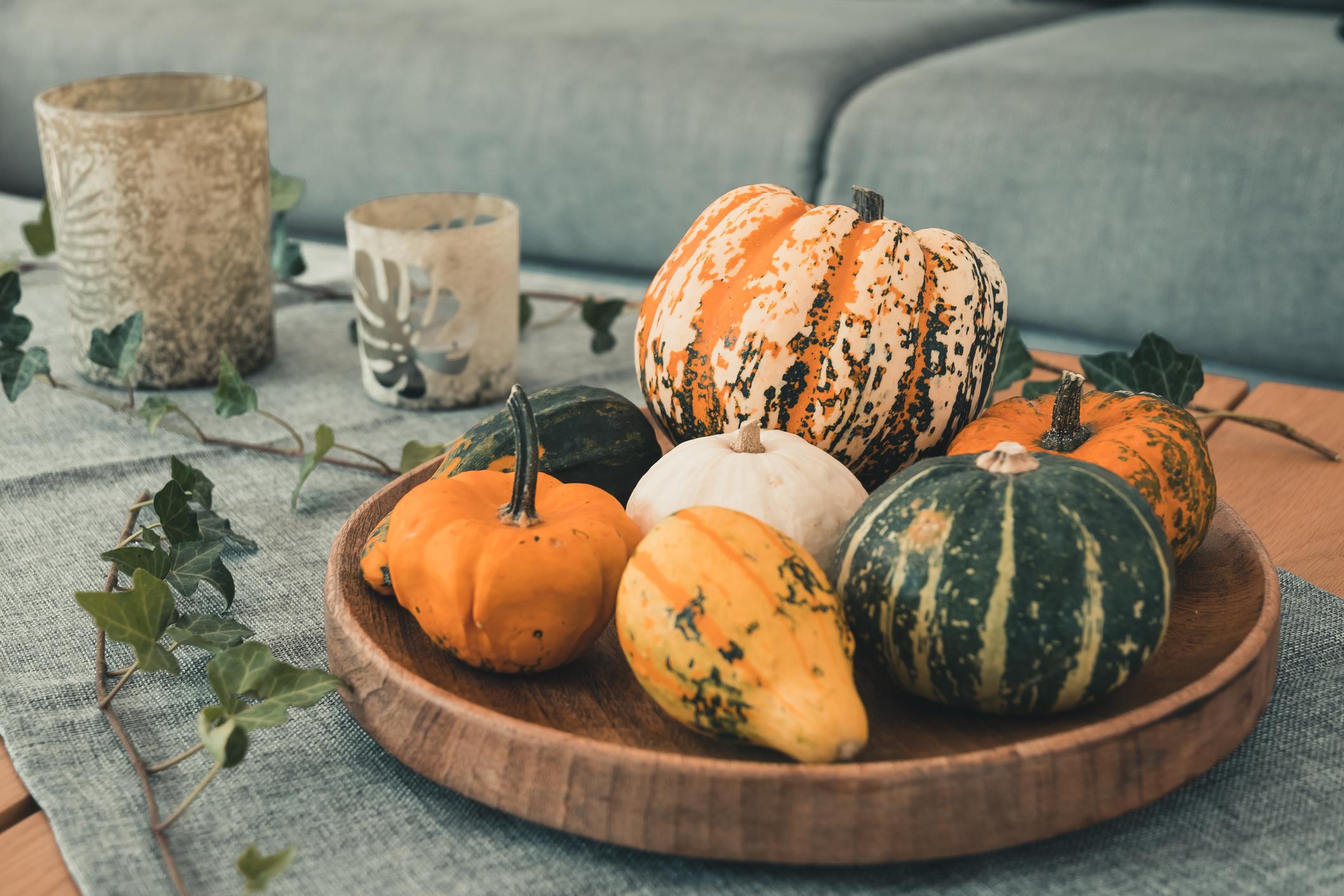 Kürbisse in einer Schale umrahmt mit Efeu.