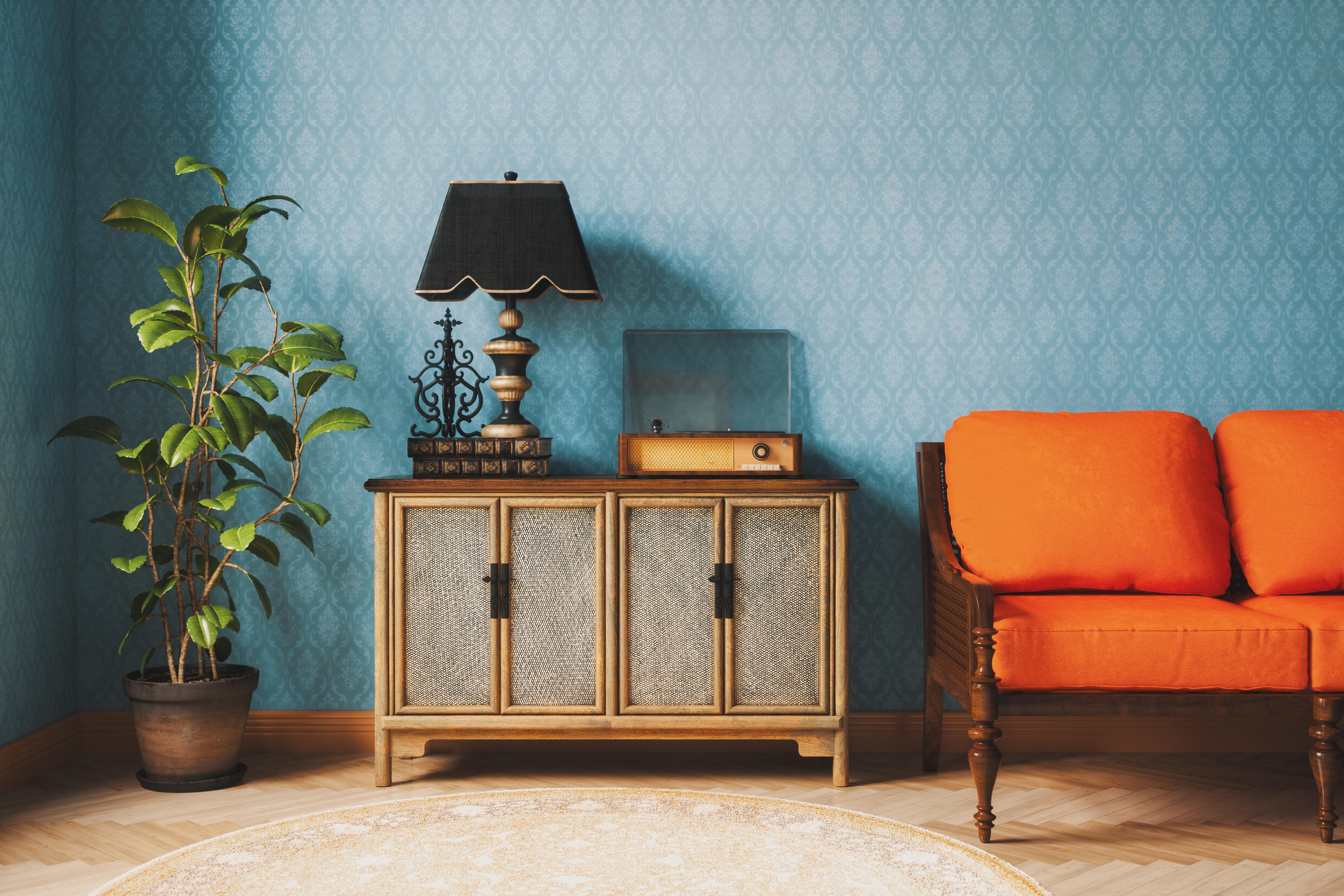 Eine Vintage-Lampe, eine Couch in Orange und ein alter Plattenspieler.